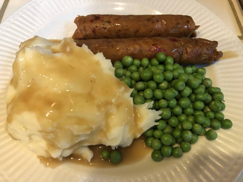 homage to Linda McCartney vegetarian sausages served with peas and mashed potatoes