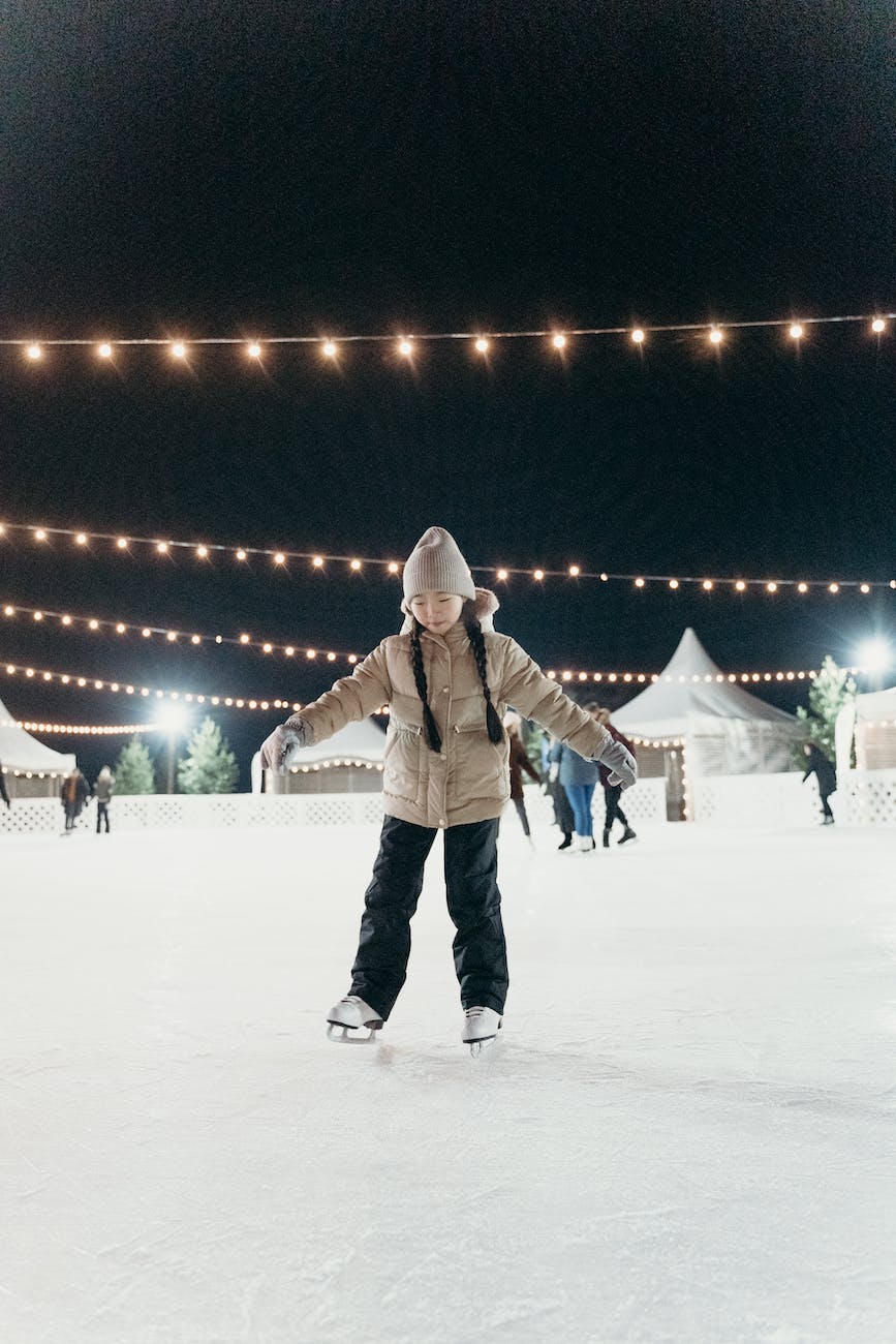 a girl wearing brown dawn jacket skating on ice rink