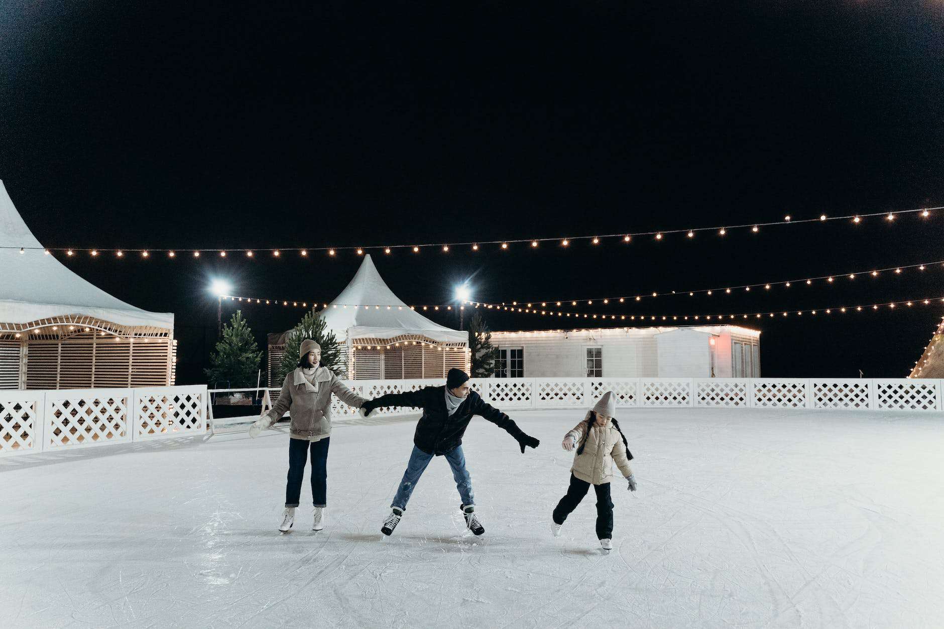 family enjoying ice skating at nighttime