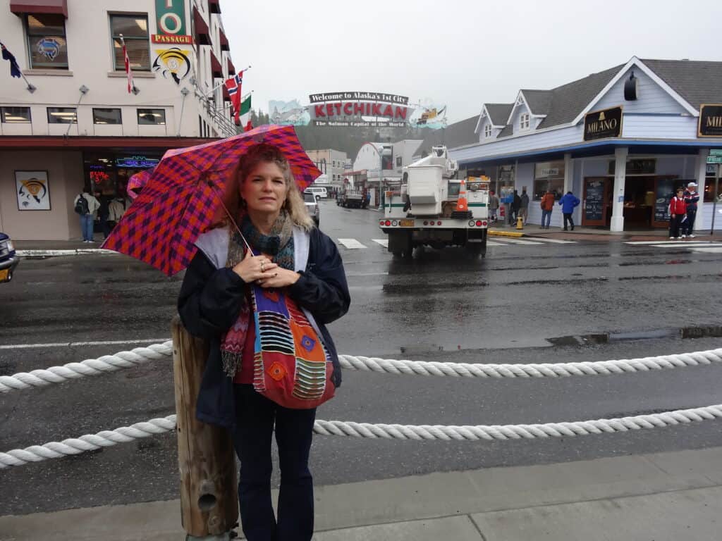 Julie from The Places Where We Go in front of Ketchikan sign that says Welcome to Alaska's 1st City