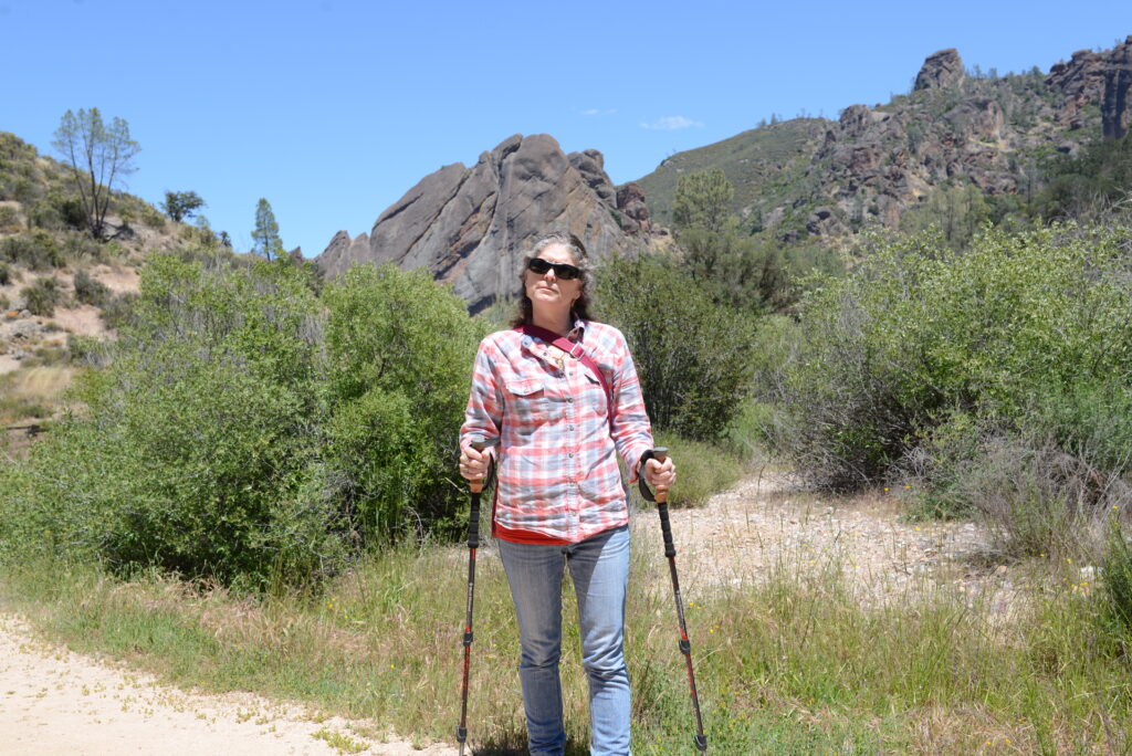 Julie from The Places Where We Go at Pinnacles National Park holding hiking poles