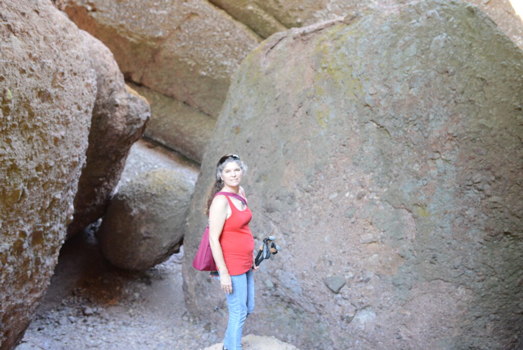 Julie from The Places Where We Go standing in front of several rocks at Pinnacles National Park