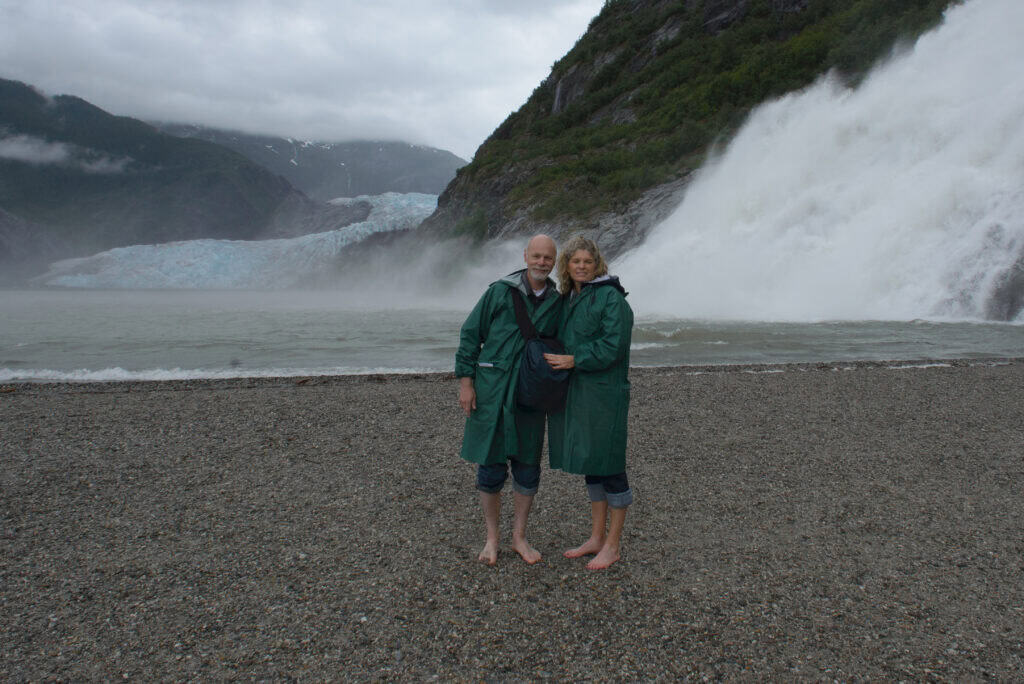 Couple standing in front of Mendenhall Glacier in Juneau Alaska