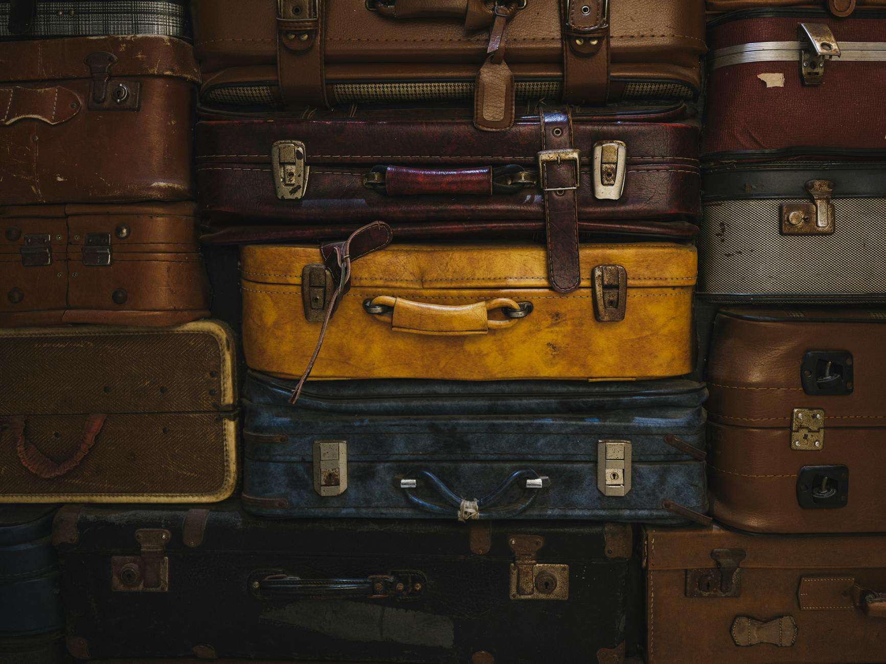 stack of vintage luggage in rustic setting