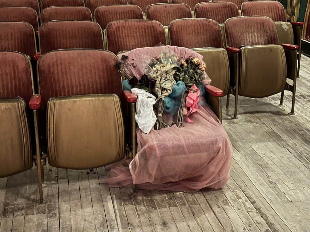 Marta Becket's chair inside the Amargosa Opera House covered with flowers
