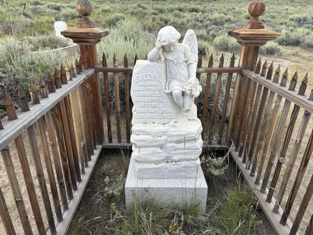 white tombstone with small child holding flowers